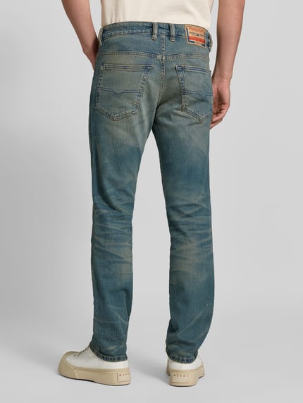 Männermodel trägt Slim Fit Jeans aus Baumwoll-Mix von Diesel, blauer Used-Look, 5-Pocket-Design, Ganzkörperansicht Rückansicht.