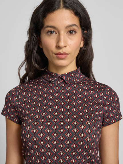 Frauenmodel trägt Slim Fit T-Shirt mit Polokragen von Marc Cain im Allover-Look, Baumwoll-Elasthan-Mix, Nahaufnahme Oberkörper.