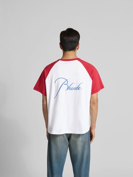 Männermodel trägt T-Shirt mit Label-Stitching von RHUDE in Weiß mit roten Ärmeln aus Reiner Baumwolle, Gerade Passform, Rückenansicht, Rückenlänge bei Größe M 68 cm.