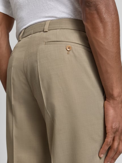 Männermodel trägt Anzughose aus Schurwolle-Elasthan-Mix Modell 'Sendrik' von Carl Gross, beige, strukturierte Oberfläche, Nahaufnahme Rückansicht. Regular Fit mit Bügelfalten und Gesäßtasche, Bundweite 40 cm, Innenbeinlänge 85 cm.