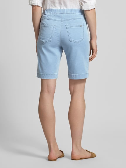 Vrouwenmodel draagt Straight Fit Shorts met achterzakken model 'Sue' van TONI, elastische katoenmix, lichtblauw, volledig van achteren, context: dames shorts, elastische tailleband, taillewijdte maat 36: 38 cm, binnenbeenlengte maat 36: 25 cm.