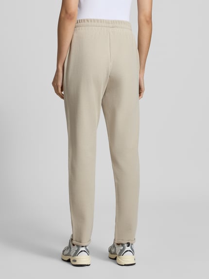 Vrouwenmodel draagt Regular Fit Sweathose uit katoenmix van JOOP! voor dames in lichtbeige, effen structuur, volledige achteraanzicht.