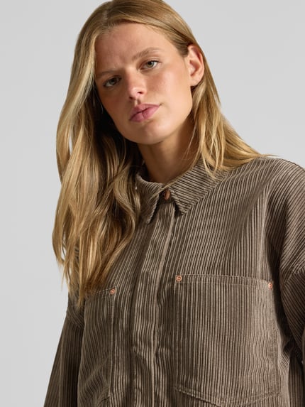 Frauenmodel trägt Oversized Hemdjacke mit verdecktem Druckknopfverschluss Modell 'JANINE-RAI' von ONLY, braune Rippenstruktur, Nahaufnahme Oberkörper, Damen Hemdjacke von ONLY