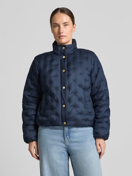Frauenmodel trägt Regular Fit Daunenjacke mit Logo-Stitching von Tommy Hilfiger in Dunkelblau, glatte Textur, Ganzkörperansicht von vorne, Damen Daunenjacke