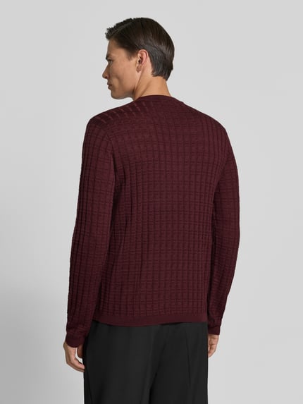 Männermodel trägt Strickpullover mit Struktur-Muster von Emporio Armani in Dunkelrot, Material-Mix, tailliert, Rückansicht, Rückenlänge 62 cm.