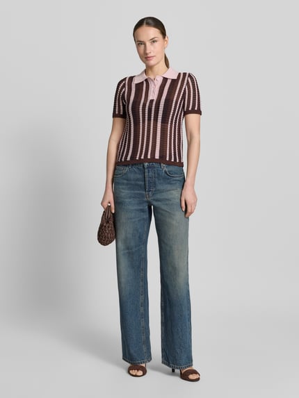 Frauenmodel trägt Modern Fit Poloshirt in Strick-Optik Modell 'PETRA' von Mango im Braun-Rosa-Streifenmuster, Baumwoll-Mix, Polokragen, kurze Knopfleiste, Rückenlänge 53 cm, Ärmellänge 23 cm, Ganzkörperansicht von vorne.