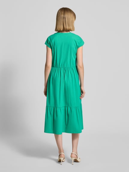 Frauenmodel trägt Knielanges Kleid im Stufen-Look mit V-Ausschnitt von ROBE LÉGÈRE im kräftigen Grün, Baumwoll-Mix mit Stretch-Anteil, A-Linie, Kappärmel, Rückenlänge 104 cm, Brustweite 46 cm, Ganzkörperansicht Rückansicht.