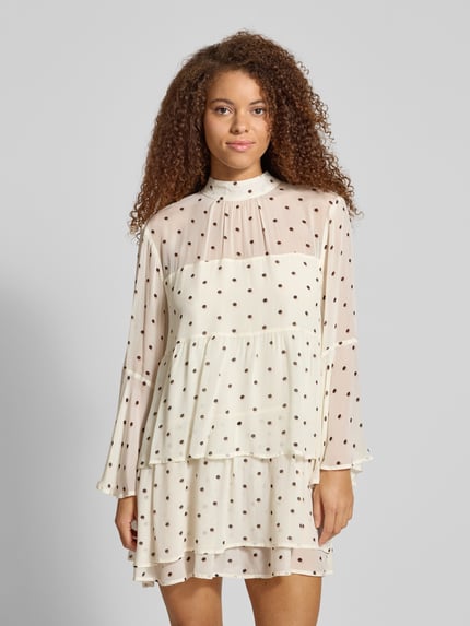 Frauenmodel trägt Minikleid aus Viskose mit Volants Modell 'Lavinia' von OH APRIL, cremefarben mit Punkten, Stufen-Look, A-Linie, Ganzkörperansicht von vorne.