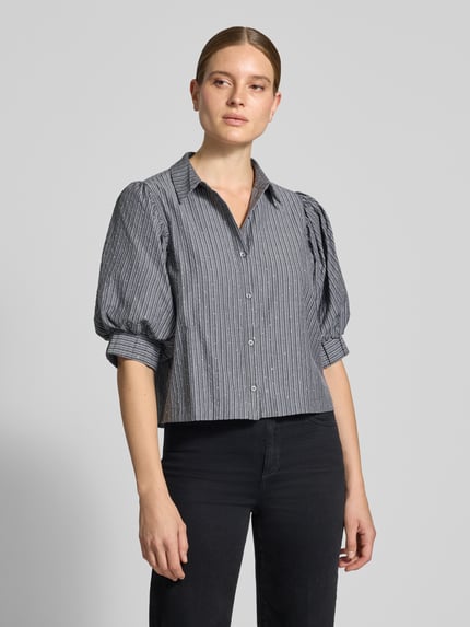 Frauenmodel trägt Bluse mit Puffärmeln Modell 'Etta' von Neo Noir, grau gestreifter Material-Mix mit Stretch-Anteil, Boxy Fit, Ganzkörperansicht von vorne.