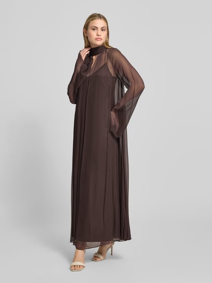 Vrouwenmodel draagt Maxikleid aus Viskose mit Stehkragen Modell 'ESTHER' van Staud, losse pasvorm, semitransparant, donkere tinten, volledige lichaamsaanzicht schuin van voren.