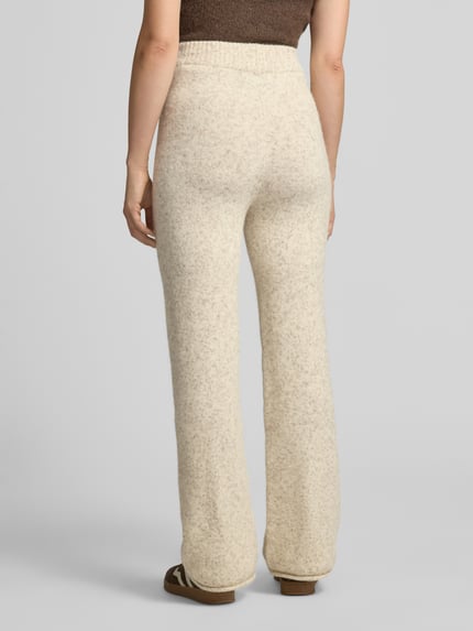 Frauenmodel trägt Hose mit Strickoptik von VERO MODA in Beige mit elastischem Bund und weitem Schnitt, Ganzkörperansicht Rückansicht.