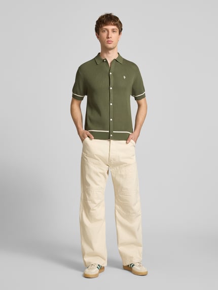 Męski model nosi Slim Fit Strick-Poloshirt mit Label-Stitching od REVIEW, zielony z białymi paskami, krój slim fit, pełny przód