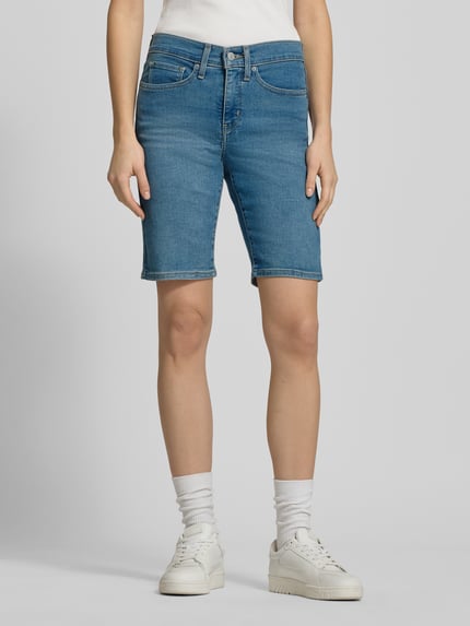 Vrouwenmodel draagt Regular Fit Bermuda in Denim-Optik van Levi's®, blauwe katoenmix, 5-pocket, knoop- en ritssluiting, vooraanzicht volledig lichaam.