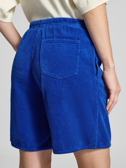 Frauenmodel trägt Shorts mit elastischem Bund Modell 'PADOW' von American Vintage, blaue Viskose mit Gesäßtasche, lockerer Schnitt, Ganzkörperansicht Rückansicht