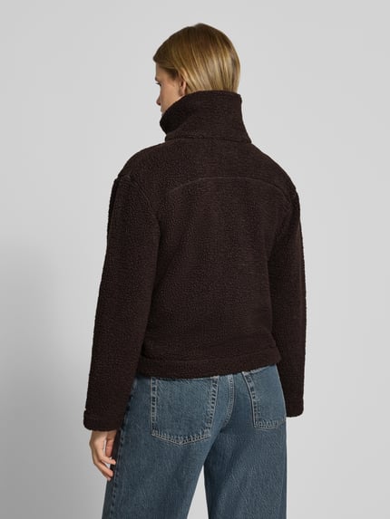 Vrouwenmodel draagt Teddyjacke met hohem Stehkragen van ONLY, donkerbruin, grove structuur, rechte vormen, Ganzkörperansicht Rückansicht. Dames Teddy- / Webpelzjacke van ONLY.