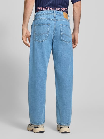 Männermodel trägt Straight Fit Jeans aus reiner Baumwolle Modell 'Ted' von JACK & JONES, 5-Pocket-Design, hellblaue Farbe, Ganzkörperansicht Rückansicht.