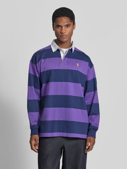 Männermodel trägt Oversized Pullover aus reiner Baumwolle Modell '6/1' von Polo Ralph Lauren in Lila-Blau mit Streifen, Ganzkörperansicht von vorne, Herren Pullover von Polo Ralph Lauren.