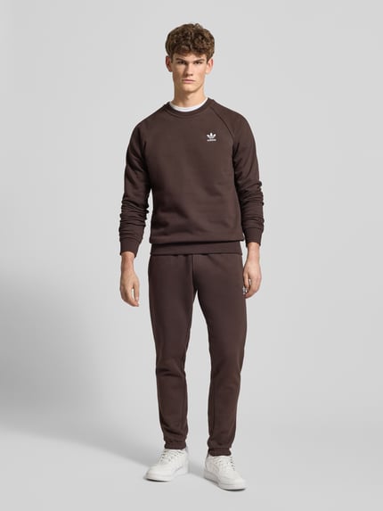 Männermodel trägt Sweatpants mit elastischem Bund von adidas Originals aus Baumwoll-Mix, Lockerer-Schnitt, Eingrifftaschen, Label-Stitching, Ganzkörperansicht von vorne.