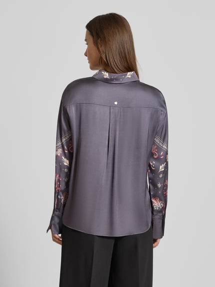 Kobiece modelka nosi Blusenshirt mit kurzer Knopfleiste od Marc Cain z czystej wiskozy, luźny krój, szary kolor z wzorem, widok z tyłu, całopostaciowy.
