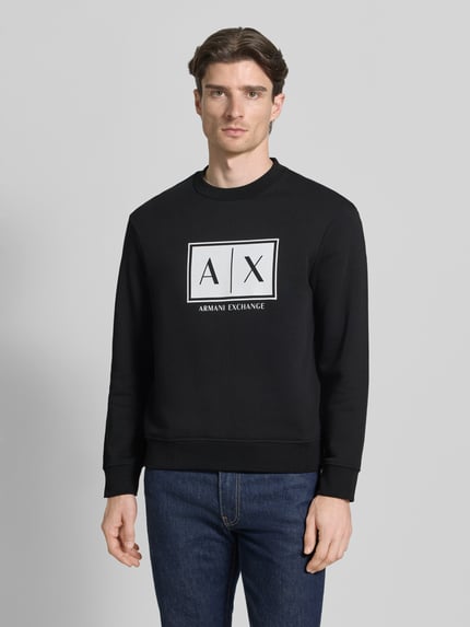 Mannenmodel draagt 'Sweatshirt mit Logo-Print und Rundhalsausschnitt' van ARMANI EXCHANGE in zwart, katoen, loose fit, logo op borst, vooraanzicht busteshot.