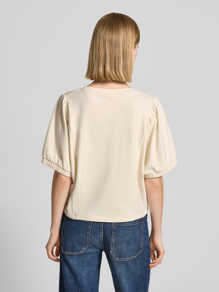 Mädchen trägt Relaxed Fit Sweatshirt mit Rundhalsausschnitt Modell 'Aurati' von Drykorn, kremowy bawełniany półrękaw, elastyczne mankiety, widok całej sylwetki z tyłu