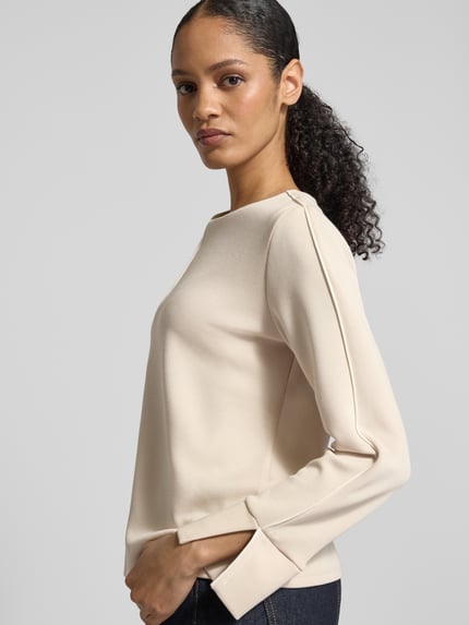 Vrouwenmodel draagt Regular Fit Sweatshirt met contrastnaden van s.Oliver BLACK LABEL, effen, lange mouw, ronde hals, modal-mix. Zijaanzicht bovenlichaam.