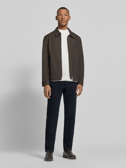 Männermodel trägt Straight Fit Jeans Modell 'Cadiz' von Brax in dunkelblauer Denim-Optik, 5-Pocket-Design, Baumwoll-Mix, Ganzkörperansicht von vorne.