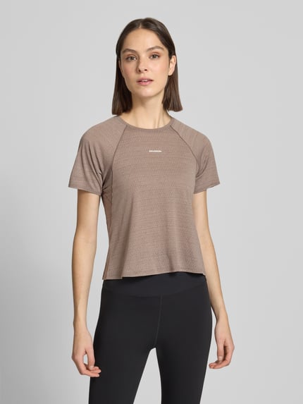 Vrouwenmodel draagt Cropped Fit T-Shirt met logoprint van Salomon, dames t-shirt, ronde hals, met korte mouwen, ruglengte maat S 45 cm, geheellichaamsaanzicht van voren