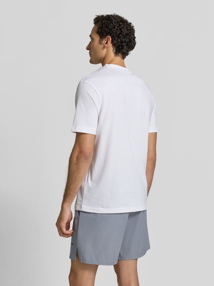 Mężczyzna model nosi biały t-shirt Regular Fit T-Shirt aus reiner Baumwolle Modell 'TS_STRUCTURE LOGO 1027473' od BOSS Green, widok całej sylwetki od tyłu.