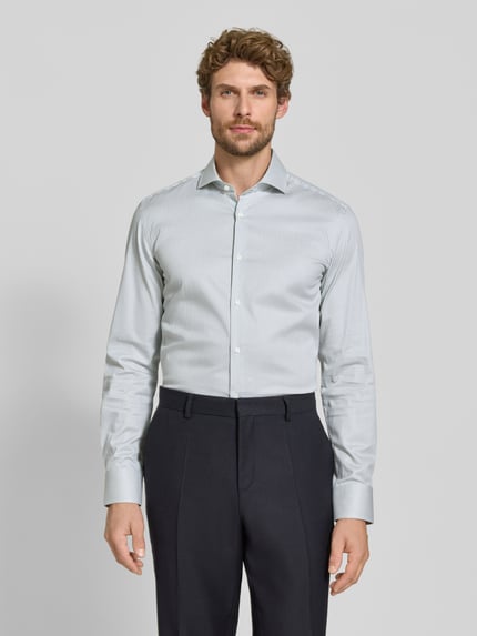 Männermodel trägt Slim Fit Businesshemd aus Baumwoll-Mix Modell 'HANK' von BOSS, helles Streifenmuster, glatte Textur, Ganzkörperansicht von vorne, Herren Businesshemd von BOSS.