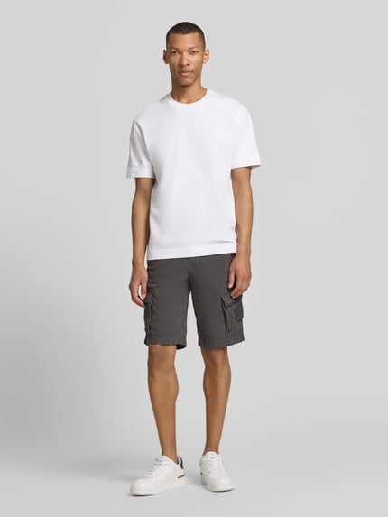 Männermodel trägt Bermudas mit Pattentaschen und Label-Stitchings von PME Legend in Dunkelgrau mit Straight Fit und seitlichen Eingrifftaschen, Knopf-Reißverschluss, Motiv- und Label-Stitchings, Label-Details, Ganzkörperansicht von vorne.