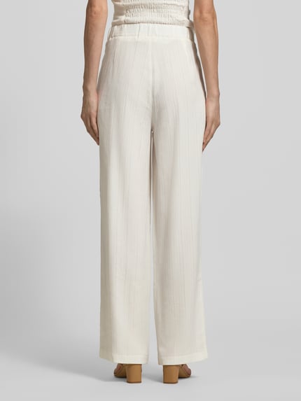Frauenmodel trägt Hose aus Viskose-Mix mit Strukturmuster von Little Mistress, relaxed Fit, cremefarben, Ganzkörperansicht Rückansicht.