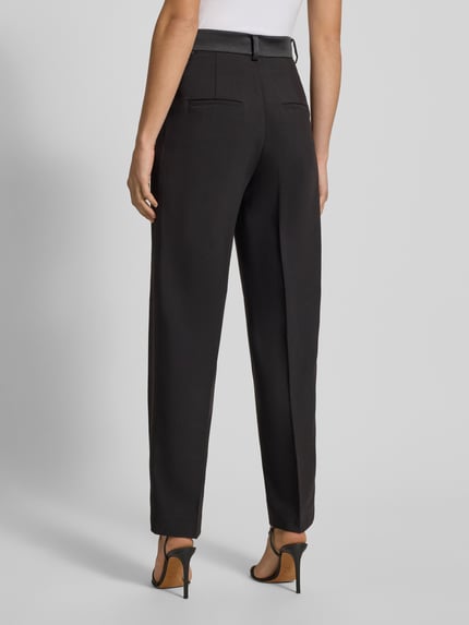 Frauenmodel trägt High Rise Stoffhose mit Gesäßtaschen von Bardot im schwarzen Material-Mix mit Viskose-Anteil, Bügelfalten, Ganzkörperansicht Rückansicht.