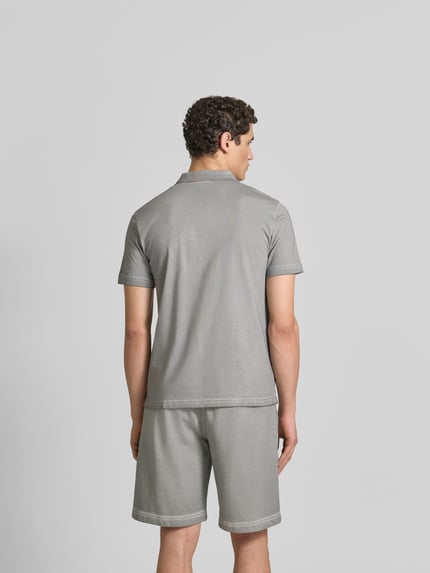 Męski model nosi Regular Fit Poloshirt aus Baumwolle od Diesel, szary, kołnierzyk polo, z krótkim rękawem, krój regular fit, detale z logo, bawełna, długość tyłu w rozmiarze M: 70 cm, widok całej sylwetki z tyłu.
