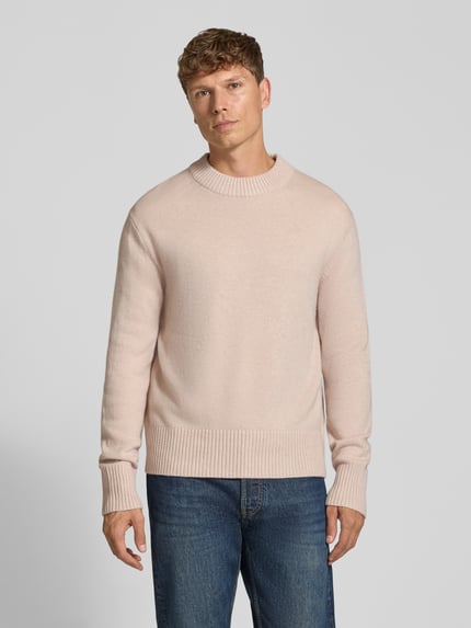 Männermodel trägt Pullover aus Kaschmir mit Rippabschlüssen von Selected, Melange-Optik, Rundhals, Woll-Kaschmir-Mix, Ganzkörperansicht von vorne.