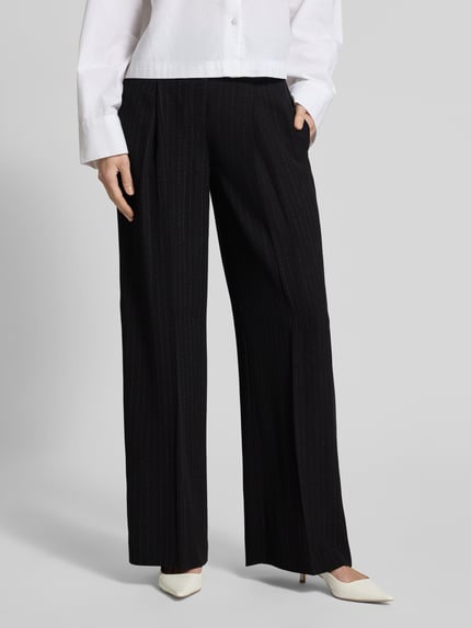 Frauenmodel trägt Weite Hose aus reiner Viskose Modell 'TIANA4' von BOSS mit Nadelstreifen, Allover-Muster, seitlichen Taschen, Nahaufnahme Unterkörper.