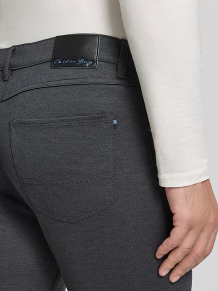 Männermodel trägt Stoffhose mit französischen Eingrifftaschen van Christian Berg Men, rechtssnit, grijze kleur, detailaufnahme Rückansicht.