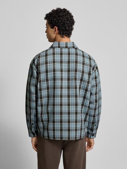 Męskim modelem nosi Koszulę casualową Regular Fit Freizeithemd mit Label-Stitching od Pegador, model Rupit, krata niebiesko-czarna, kołnierzyk typu kent, listwa guzikowa, długość tyłu 72 cm, szerokość ramion 59 cm, długość rękawów 61 cm, widok całej sylwetki z tyłu.