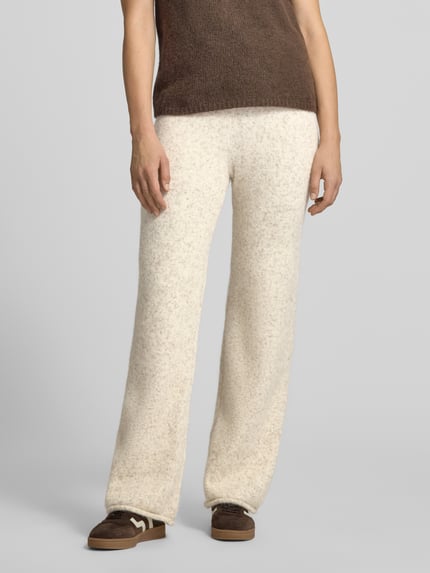 Frauenmodel trägt Hose mit Strickoptik von VERO MODA in cremefarben, gerader Schnitt, elastischer Bund, Strickstruktur, Nahaufnahme Unterkörper. Damen Weite Hose mit Tunnelzug, Schlupfverschluss, Material in Strickoptik.