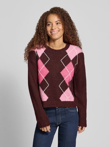 Vrouwenmodel draagt Relaxed Fit gebreide pullover uit wolmix Model 'HARVI' van JJXX met ruitmotief in roze en bordeaux, Dames, ruglengte maat S 50 cm, mouwlengte maat S 57 cm, voorkant bovenlichaam close-up.