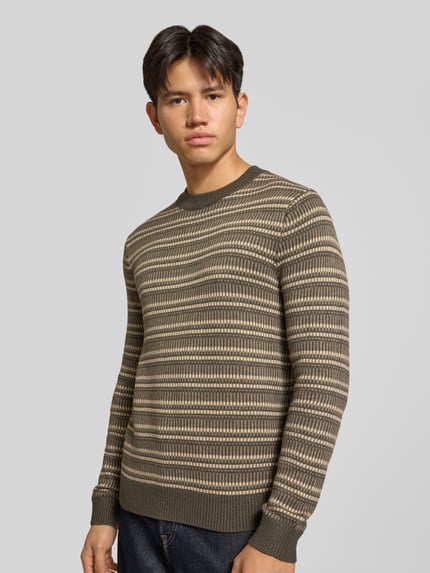Männermodel trägt Regular Fit Strickpullover aus Baumwoll-Mix mit Strukturmuster von ONLY & SONS in Beige und Khaki, Ganzkörperansicht von vorne.