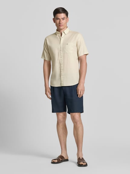 Männermodel trägt Slim Fit Freizeithemd aus Leinen-Baumwoll-Mix von Fynch-Hatton in Beige mit Brusttasche, Ganzkörperansicht von vorne.