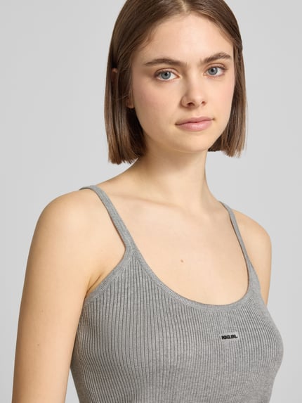 Frauenmodel trägt Tanktop aus Viskose-Mix mit tiefem Rückenausschnitt von Karo Kauer, Feinripp, Rundhalsausschnitt, Körpernaher-Schnitt, Nahaufnahme Oberkörper.