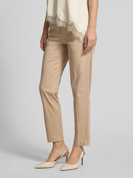 Frauenmodel trägt Hose in verkürzter Passform Modell 'MARON' von Brax in Beige, Baumwoll-Mix mit Lyocell, Ganzkörperansicht von vorne.