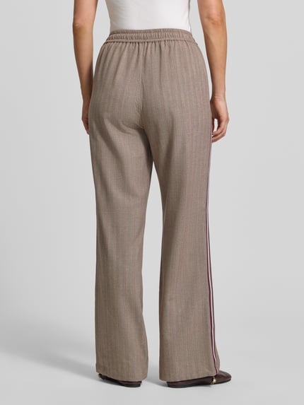 Vrouwenmodel draagt Wide Fit broek met viscose van Liu Jo, elastische materiaalmix, steekzakken, logodetail, band met tunnelkoord, binnenbeenlengte maat S 80 cm, bandwijdte 38 cm, geheel van achteren