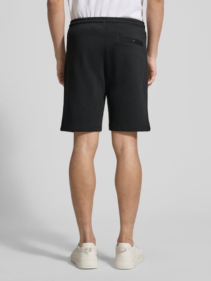 Männermodel trägt Shorts mit elastischem Bund von Christian Berg Men, schwarz, Baumwoll-Elasthan-Mix, Regular Fit, Ganzkörperansicht Rückansicht