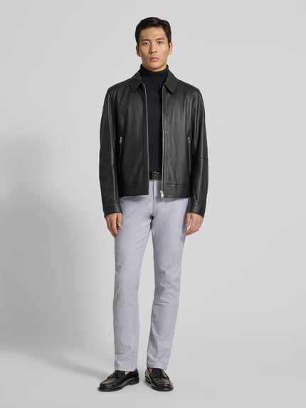 Męski model nosi Stoffhose mit französischen Eingrifftaschen od MCNEAL, prosta nogawka, jasnoszary, bawełna z elastanem, widok całej sylwetki z przodu.