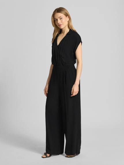 Frauenmodel trägt schwarzen Jumpsuit aus Viskose mit V-Ausschnitt Modell 'MARRAKECH' von ICHI, Wickel-Optik, Ganzkörperansicht von vorne