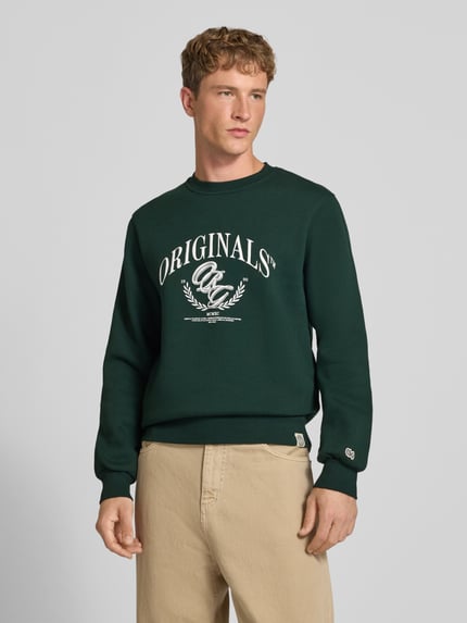 Männermodel trägt dunkelgrünes Sweatshirt mit Label-Print Modell 'FREDERIKSBERG' von JACK & JONES, Baumwoll-Mix, Nahaufnahme Oberkörper.
