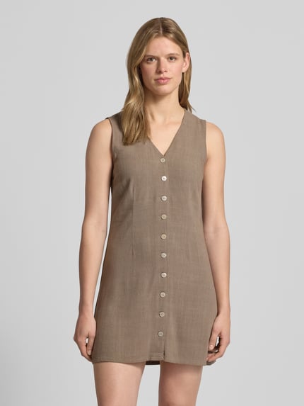 Vrouwenmodel draagt tailliertes Freizeitkleid aus Viskose-Leinen-Mix Modell 'SIESTA' van Only, effen, getailleerd fit, mini lengte, V-hals, knoopsluiting, mouwloos, flammégaren, voorkant geheel in beeld, Ganzkörperansicht von vorne.